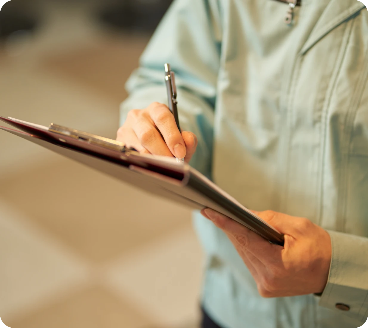 Hand holding clipboard and pen